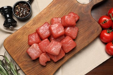 Raw beef meat and different ingredients for cooking delicious goulash on wooden table, flat lay