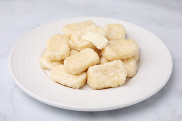 Fototapeta na wymiar Plate of tasty lazy dumplings with butter on white marble table