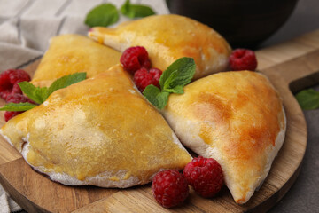 Delicious samosas with raspberries on grey table, closeup