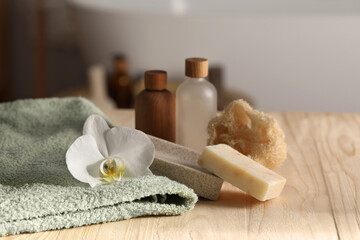 Fototapeta na wymiar Composition with spa products and plumeria flower on wooden table in bathroom, closeup. Space for text