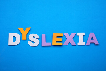 Obraz premium Word Dyslexia made of paper letters on blue background, flat lay