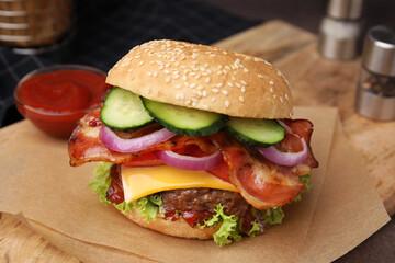 Tasty burger with bacon, vegetables and patty on table, closeup