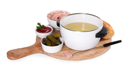 Oil in fondue pot, fork, pieces of raw meat, pickles and sauce isolated on white