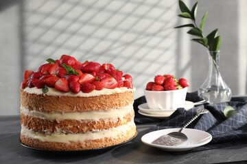 Tasty cake with fresh strawberries and mint served on gray table