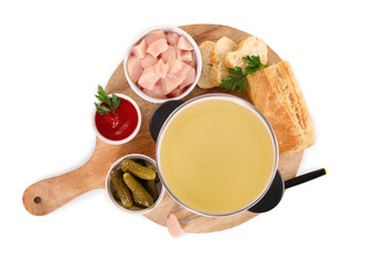 Oil in fondue pot, fork, pieces of raw meat and other products isolated on white, top view