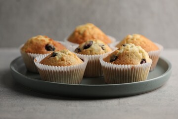 Delicious sweet muffins with berries on grey table, closeup