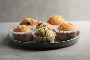 Delicious sweet muffins with berries on grey table