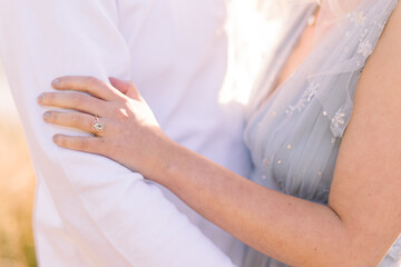 Woman's hand and fiancés arm during engagement session