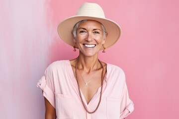 Portrait of happy senior woman in summer hat and pink blouse