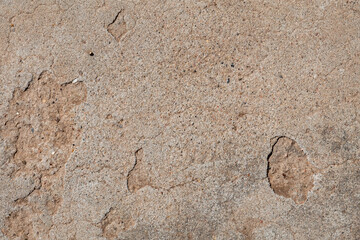 Macro image of a section of weathered  concrete floor with cracks and pock marks. The concrete has...
