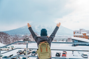 Woman tourist Visiting in Niseko, Traveler in Sweater sightseeing Yotei Mountain with Snow in...