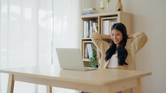 Young asian woman working at home. Female using computer laptop on desk at house