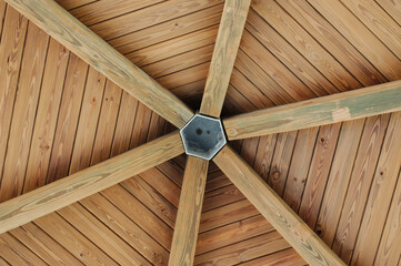 Perspective View looking up from the floor to the ceiling of a wood gazebo. Six beams around center...