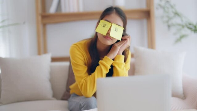 Tired adorable asian female student sleeping with stickers on eyes, sitting on couch. Beautiful gorgeous woman lazy or nap