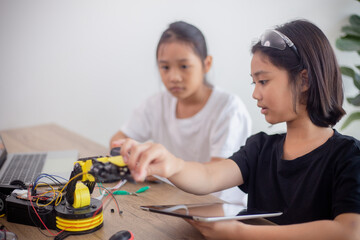 nventive kids learn at home by coding robot cars and electronic board cables in STEM. constructing robot cars at home