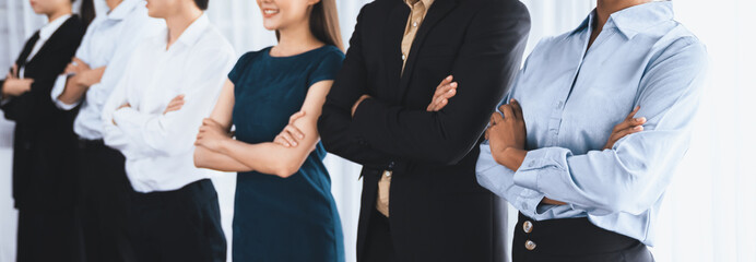 Diverse group of professional business people stand in line with cross arm gesture in modern corporate office. Happy and smiling multiracial office worker team bond and succeed together. Concord - obrazy, fototapety, plakaty