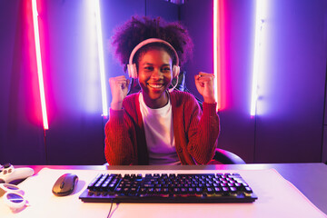 Gaming streamer, African girl playing online fighting with Esport skilled team wearing headphones...