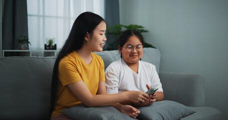 Portrait of young woman giving dollars money with teen girl for doing great work at home.