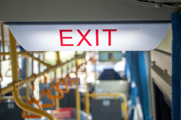 A emergency sign for exit inside a public transport bus
