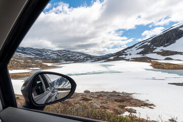 Reflection in the mirror of a car with winter landscape.
