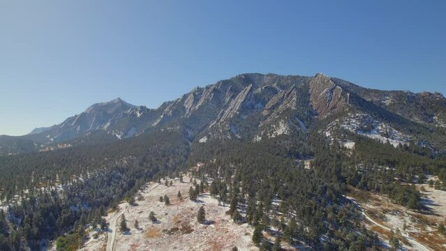 Snow covering the flatirons nature landscape on a clear fall day in Boulder, Colorado, USA Drone Aerial Video