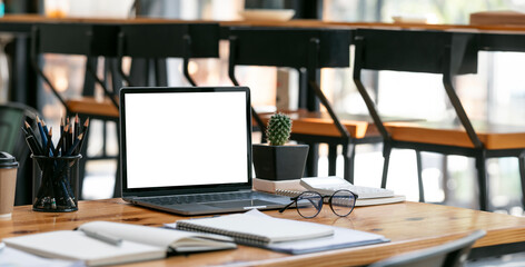 Creative workspace, mockup blank screen laptop computer on wooden table.