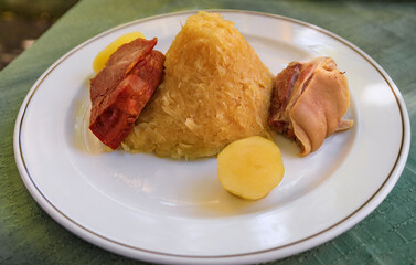 Traditional Alsacian choucroute garnie, sauerkraut with sausages, pork knuckle, other meats and potatoes at a winstub restaurant in Strasbourg, France