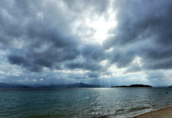 Philippines, Coron, sun rays breaking through clouds on the sea