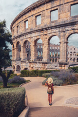 Ancient Roman amphitheatre in Pula, tourist female visiting the city in Croatia