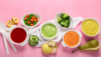Bowls with baby food on pink background. Healthy eating concept.