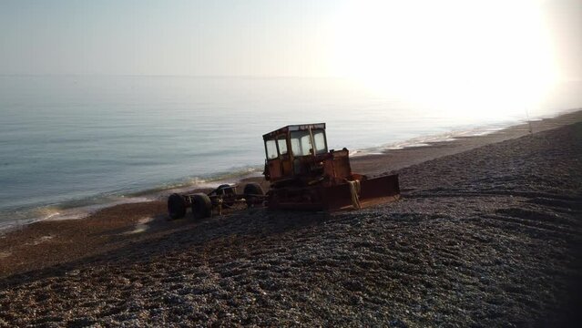 Aerial 4K Drone footage of an old boat tractor on the stoney beach of Weybourne Beach, North Norfolk.