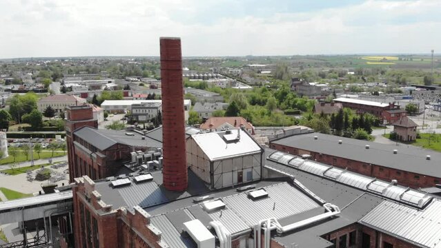 Sugar Factory Building With Smokestack In Znin, Poland. aerial sideways