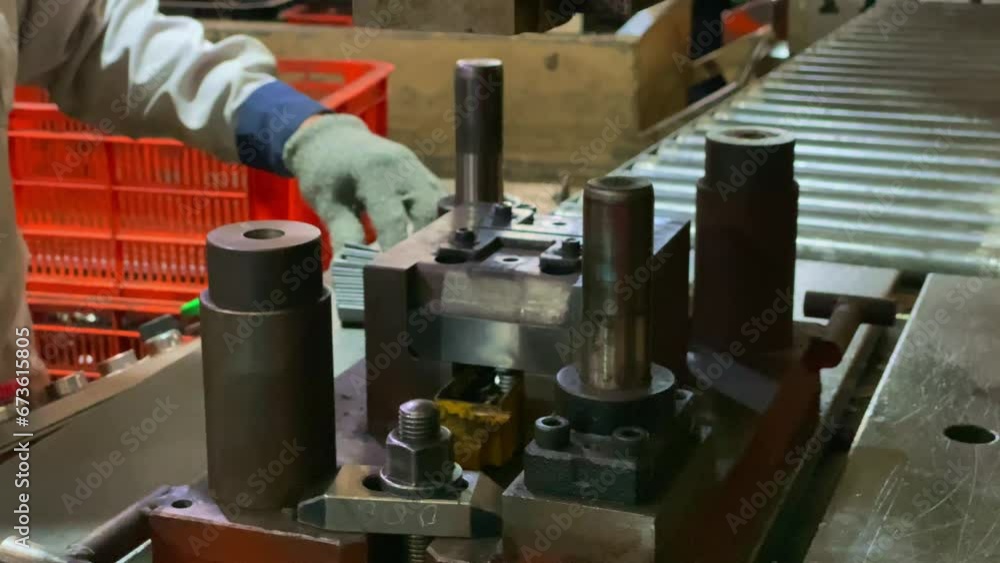 Poster working press machine, small parts are inserted into the machine. close up of worker hands