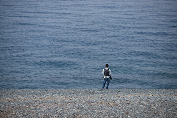 朝の海岸で海釣している男性の姿