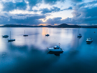 Naklejka na ściany i meble Sunrise blues over the bay with boats and clouds