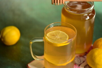 glass of tea with lemon and jar of honey