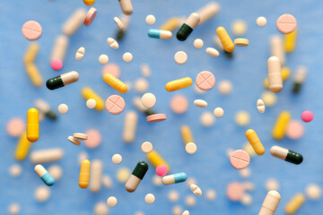 Pills, capsules with medicines on a blue background, there is space for copy.