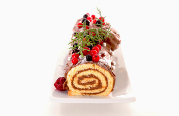 Traditional chocolate yule log christmas cake and decoration isolated on white background