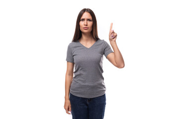 young caucasian woman with dark hair dressed in casual gray t-shirt with space for logo printing
