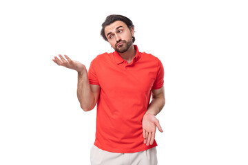 young handsome european brunette man with a beard dressed in a red t-shirt is brainstorming to solve a problem