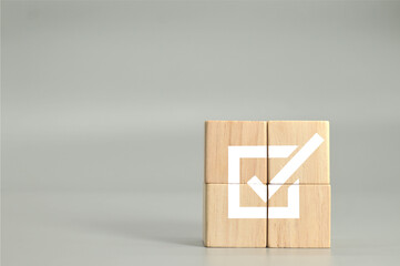 wooden cubes with checkmark icon on gray background, business success.task completion. Ethical...