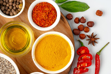 Bowls with spices on wooden board on white background