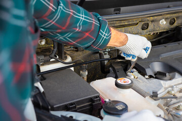 the driver unscrews the nut during the repair of the car.