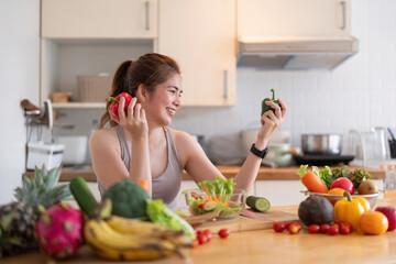 Young Asian healthy beautiful woman with casual clothes is smile and slicing fresh fruit to diet at home in kitchen in holiday