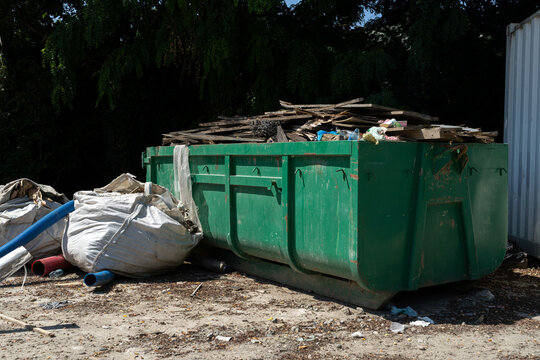 Rectangular open top roll off dumpster. Heavy duty hook lift container for garbage truck. Disposal bin used for removal of construction debris, post-renovation waste hauling, and scrap collection job.