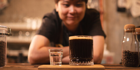 A Happy and smart female or LQBTQ coffee shop entrepreneur or barista is wearing apron stand with inspiration while looking at a coffee that she made with heart. Work life balance Startup SME business