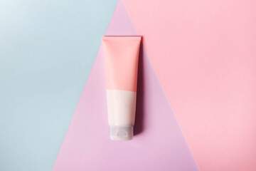 A clean label facial or body cream tube is isolated on a multi-color background. Beauty product mockup. Wellness packaging. Branding spa