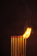 a row of matches are lit on a dark background