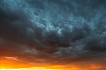 Dramatic sky at sunset, dangerous heavy gray orange color clouds in sky, abstract sky and nature...