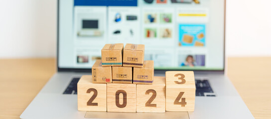 2024 New Year Online Shopping concept. Shipping Boxes on laptop computer. Sale and discount during...